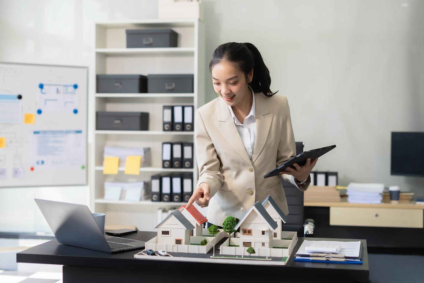 A woman looking over model homes, representing a property manager